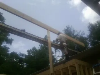 Carpenter setting a ridge beam over a new addition frame — Ice Dam Removal by Roofing Brothers in Jakin