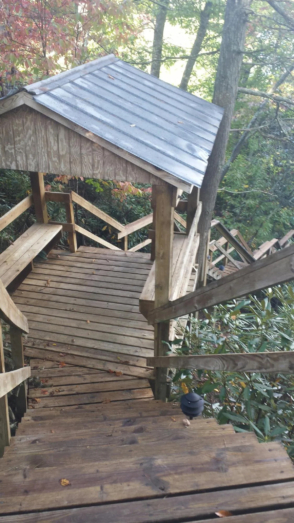 Metal roofed shelter over wooden steps on a wooded walkway — Skylight Repair & Installation work by our crew in Jakin