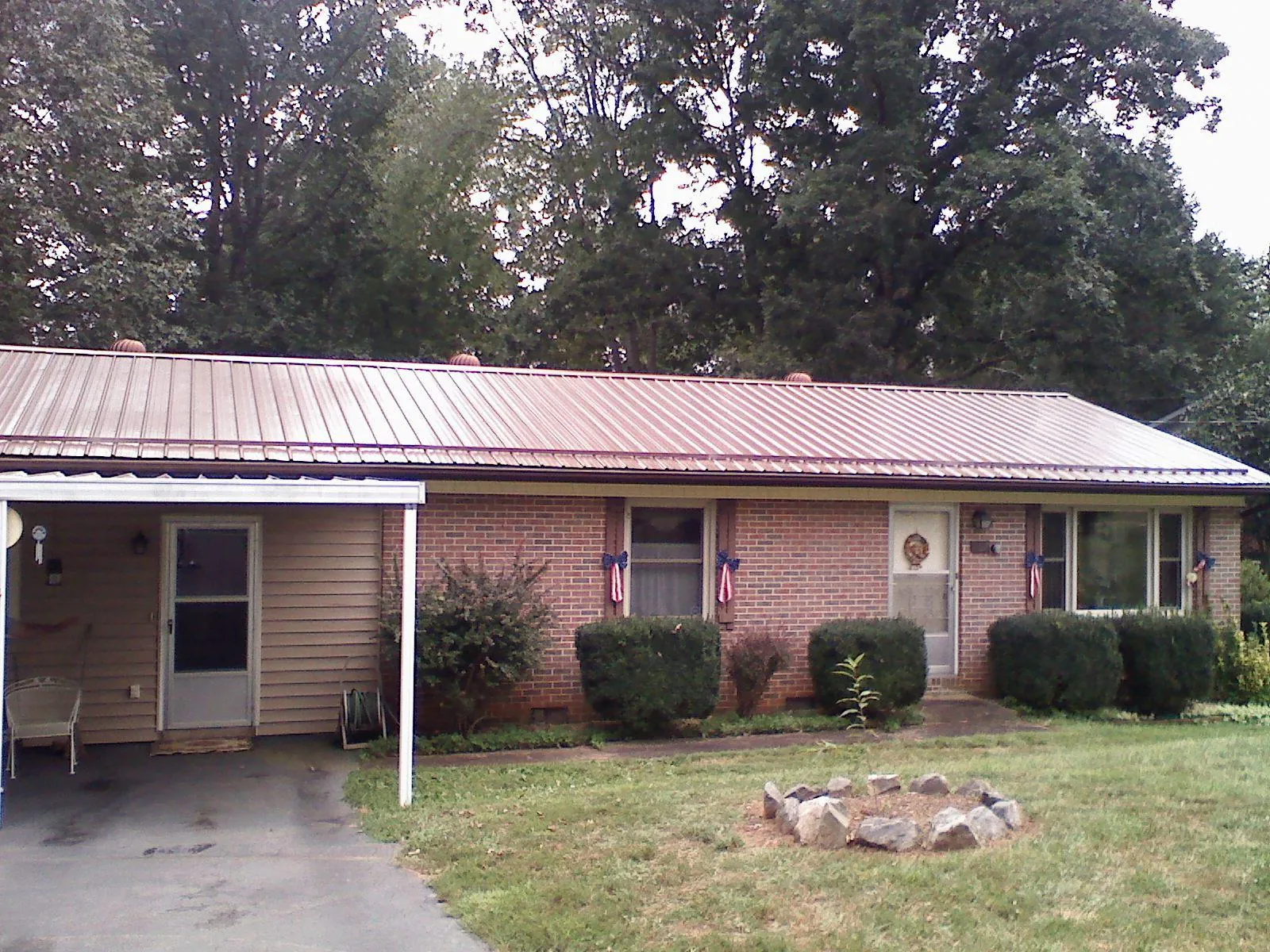 Bronze metal roof and carport on a brick ranch home — Roof Repair work by our crew in Jakin